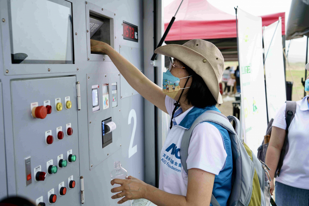 志工們將拾起的寶特瓶投入「好歸塑專車」，讓廢棄塑料空瓶可以直接粉碎、縮小體積，未來將可再製成購物袋、寶特衣、悠遊卡等生活用品